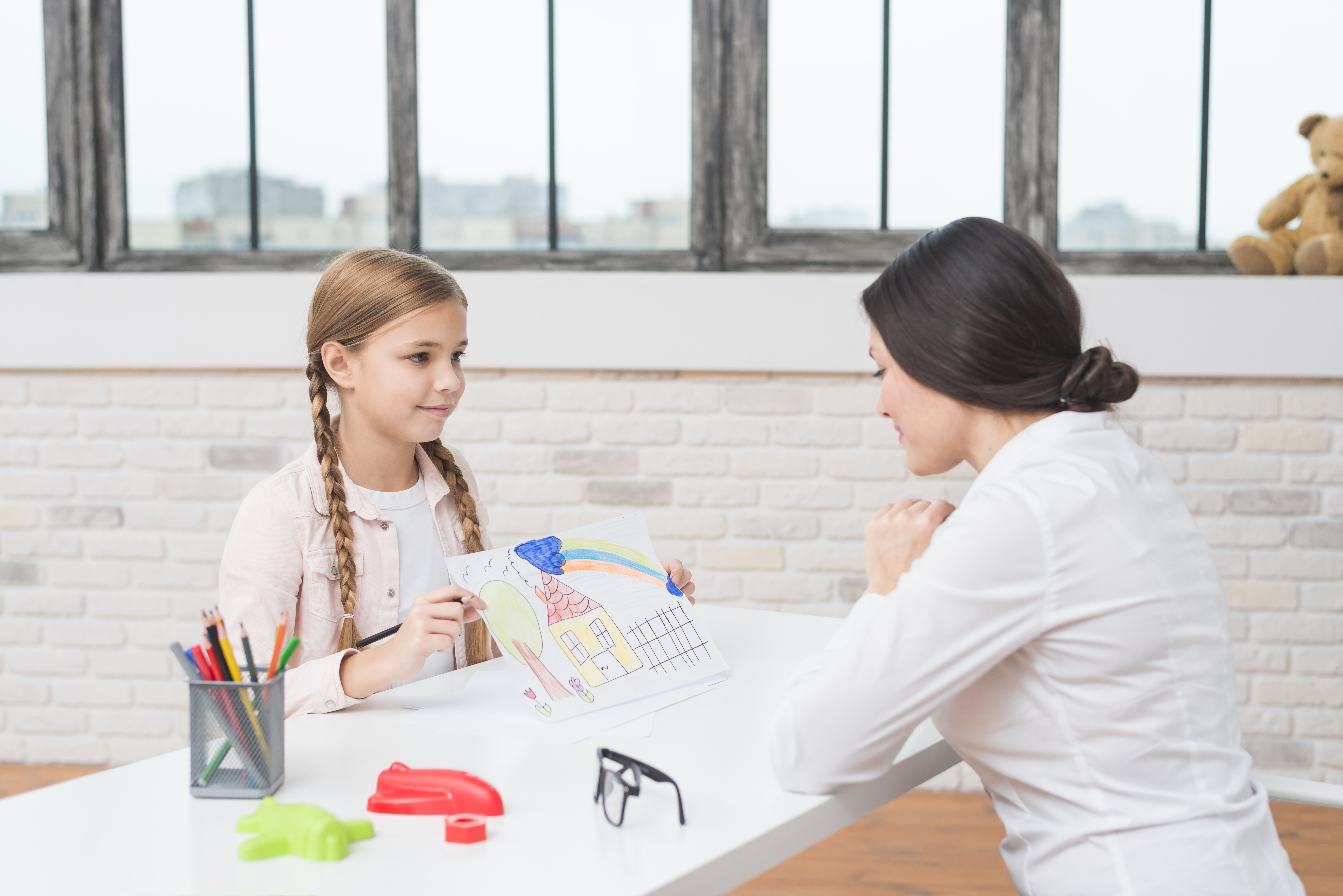 little-blonde-girl-showing-drawn-house-paper-her-female-psychologist