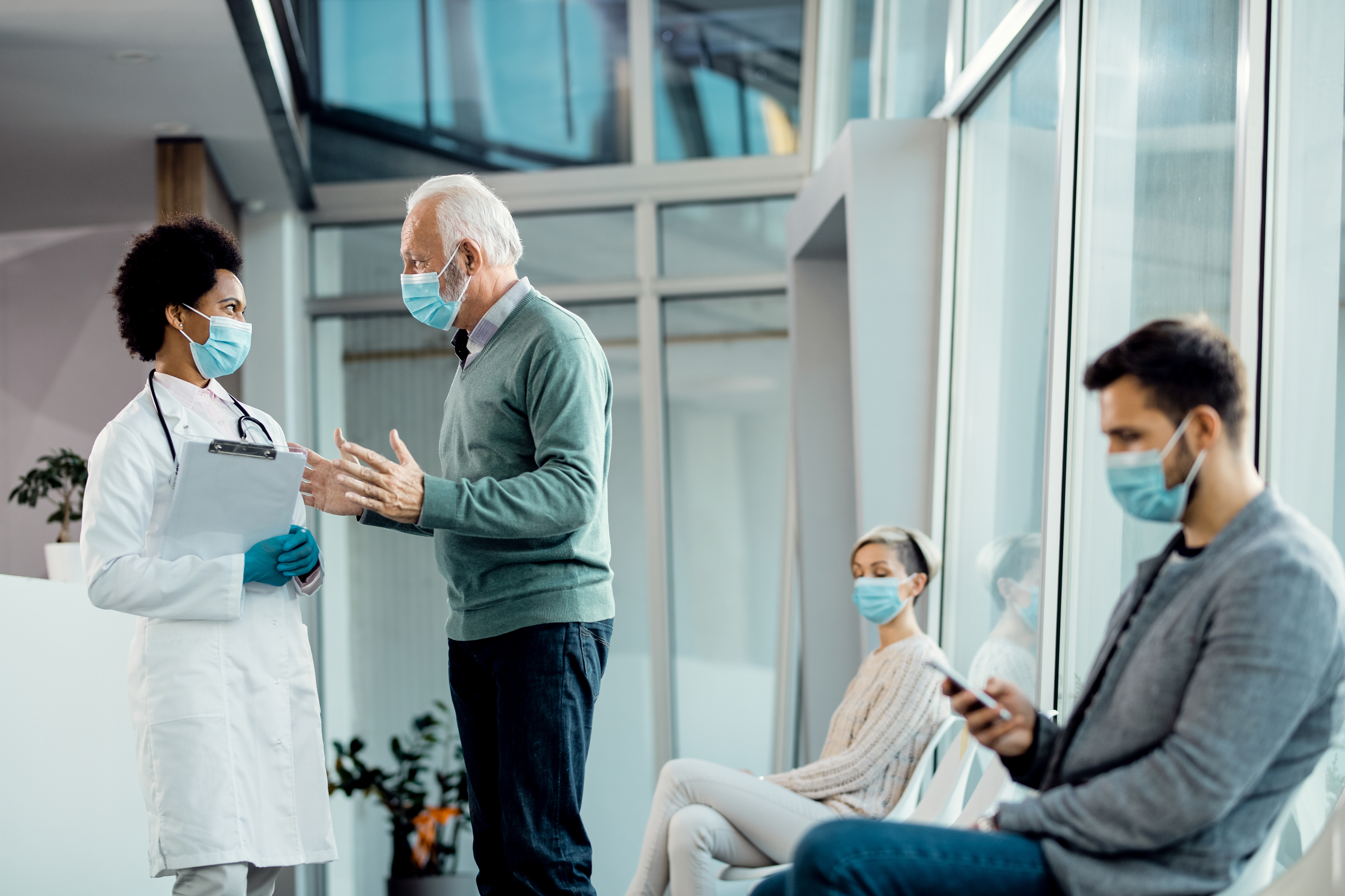 Senior man and African American doctor wearing face masks while
